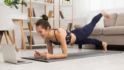 Fit,Woman,Doing,Yoga,Plank,And,Watching,Online,Tutorials,On