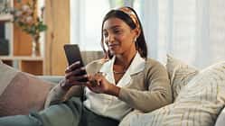 Cellphone,,Indian,Woman,And,Smile,On,Sofa,In,Home,In