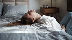 Emotional exhaustion. Tired exhausted young woman lying on bed feeling depressed