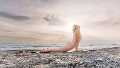 Frau macht Cobra-Position am Strand