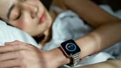 Woman sleeping peacefully in bed, wearing a smart watch to track her sleep