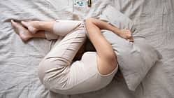 Depressed,Mature,Woman,Lying,In,Bed,With,Bottle,Of,Pills