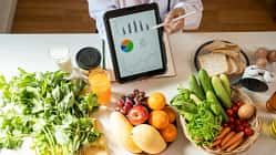 frisches Obst und ein Tablet mit einem Ernährungsplan