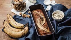 Bananenbrot mit Bananen an der Seite auf einem blauen Tuch