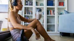 Sportlerin sitzt auf dem Boden und trinkt Proteinshake