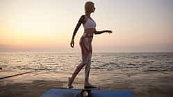 Young,Slim,Blonde,Woman,With,Tattoos,Standing,On,Wooden,Desk