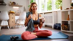 Portrait einer Frau in Sportkleidung auf einer Fitnessmatte