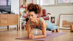 Eine Frau macht Planks auf einer Yogamatte