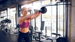 Young woman doing kettlebell exercise at gym
