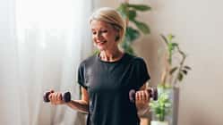 Eine Frau mittleren Alters macht Bizep-Curls mit kleinen Hanteln