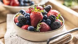 Ripe sweet different berries in a bowl on kitchen table.