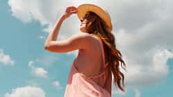 Eine Frau mit Sonnenhut genießt die Sonne