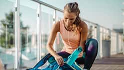 Eine Frau in Sportkleidung packt ihre Sporttasche
