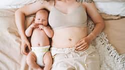 Frau liegt mit ihrem Baby im Bett