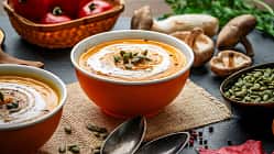 Eine Kürbissuppe in einer Schale auf einem Brett