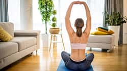 Eine Frau von hinten, wie sie auf einer Yogamatte Übungen für den Rücken praktiziert