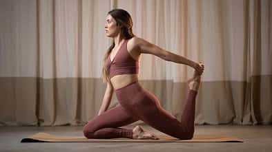 Frau macht in nachhaltiger Sportmode Yoga