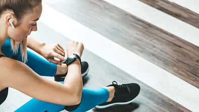 Frau in Sportklamotten bedient ihre Smartwatch