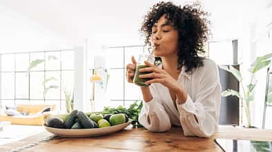 Young,African,American,Woman,Drinking,Green,Juice,With,Reusable,Bamboo