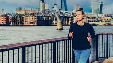Junge Läuferin, die an einem Fluss joggt