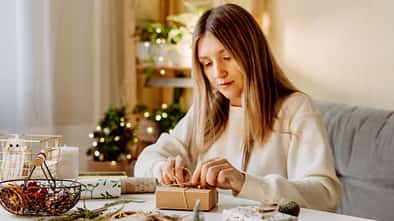 junge Frau packt Weihnachtsgeschenke ein