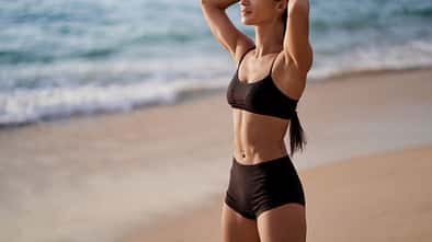 junge, trainierte Frau am Strand