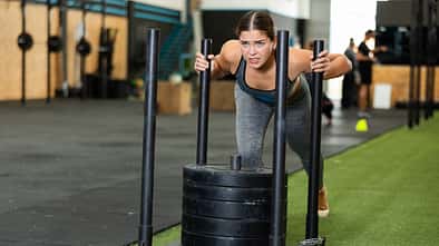 Young,Athletic,Woman,In,Sportswear,Training,On,Sled,In,Gym