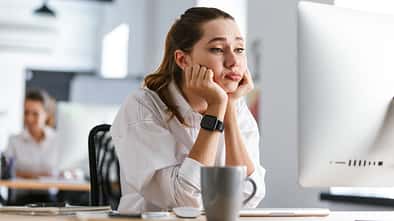 Bored,Young,Woman,Dressed,In,Shirt,Sitting,At,Her,Workplace