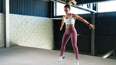 Sportliche junge Frau in Activewear macht während eines HIIT-Trainings Burpees