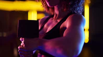 Eine trainierte junge Frau führt ein Workout mit einer Hantel durch
