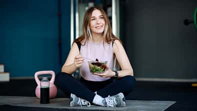 Eine junge Frau isst einen Salat