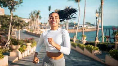 Junge Frau joggt am Wasser