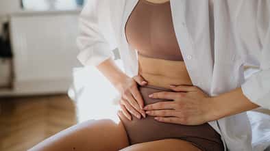 bloating,bleeding,ectopic pregnancy,woman,bladder infection,abdo Woman,At,Home,Suffering,From,Menstrual,Pain,,Having,Cramps.,Close