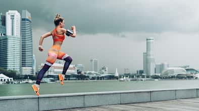 Sportlerin springt vor Skyline