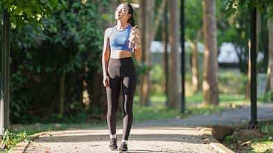 Young,Asian,Woman,,Dressed,In,Sportswear,,Walks,Along,A,Park