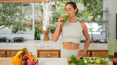 Frau trinkt Glas mit einem Green Smoothie