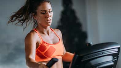 Frau im Sport-Bh am Crosstrainer