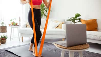 Eine Frau trainiert mit einem Theraband Eine Frau trainiert mit einem Theraband