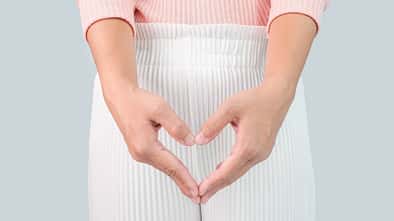 Close up view of young woman and Hand is a symbol of heart over her crotch. Feminine hygiene concept.
