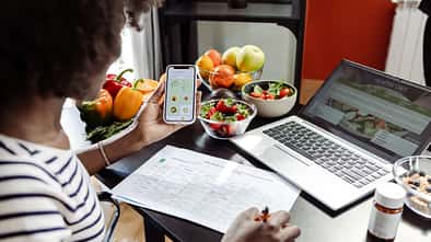 Eine Frau erstellt einen Ernährungsplan am Laptop Eine Frau erstellt einen Ernährungsplan am Laptop