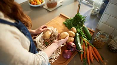 Eine Frau packt Bio-Lebensmittel in einen Beutel Eine Frau packt Bio-Lebensmittel in einen Beutel