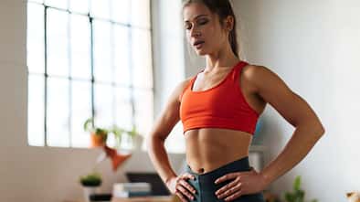 Eine trainierte Frau macht Bauchübungen im Stehen