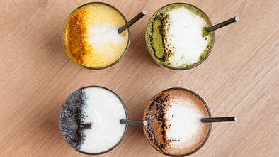 Trendy colorful latte drinks with milk foam and spices