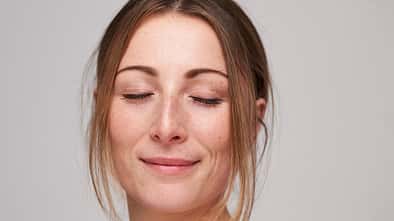 Portrait of beautiful young woman with freckles and closed eyes