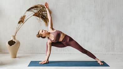 Eine Frau praktiziert Yoga auf einer Matte
