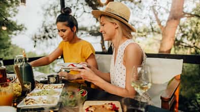 Zwei Frauen essen draußen Dinner im Sommer Zwei Frauen essen draußen Dinner im Sommer