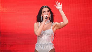 Dua Lipa performt auf der Bühne vor einem roten Hintergrund in Dublin