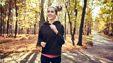 Eine junge Frau joggt im Wald