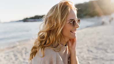 Frau mit Locken am Strand