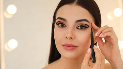 Frau trägt sich XXL-Eyeliner auf Frau trägt sich XXL-Eyeliner auf